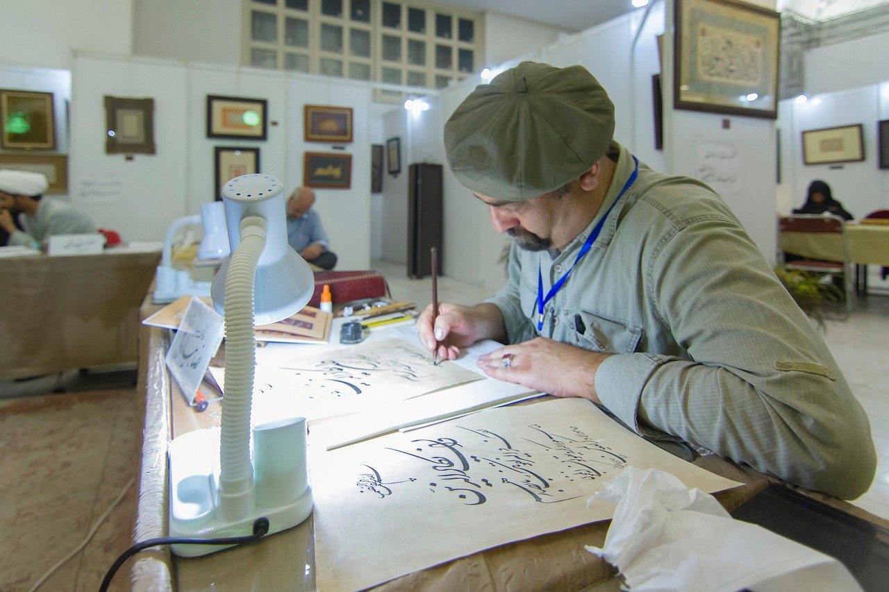 Islamic calligraphy artist creating traditional Quranic art
