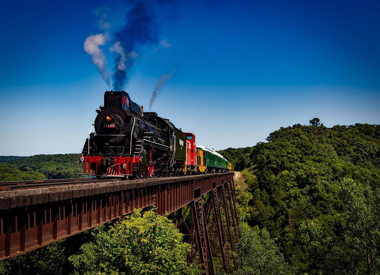 Vintage steam locomotive heritage railway with passengers on open wooden carriages