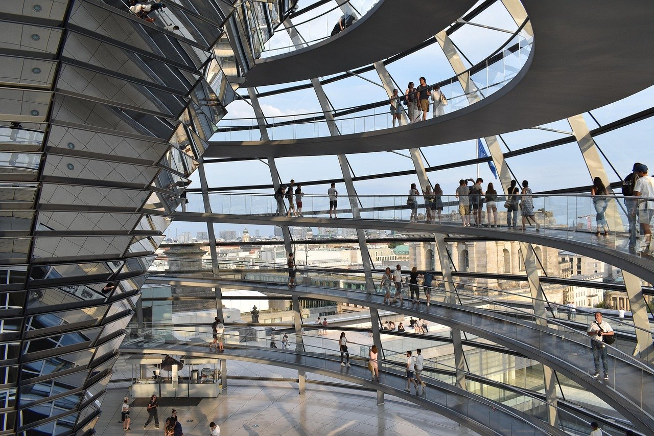 Modern glass architecture of Berlin Reichstag dome at night with city lights
