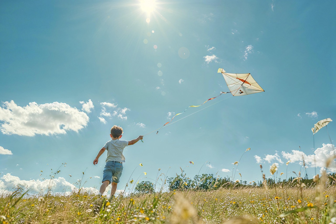 Child flying kite in open field on Tempelhofer Feld Berlin