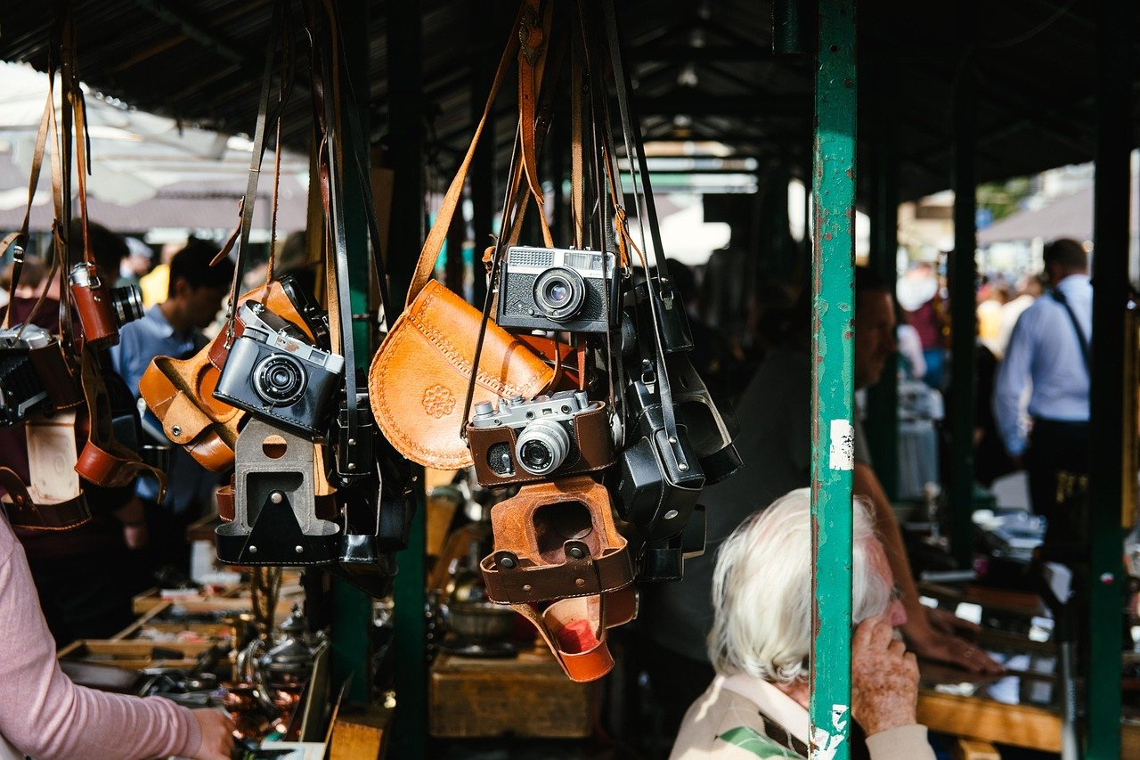 Outdoor flea market vendors with cameras and antiques
